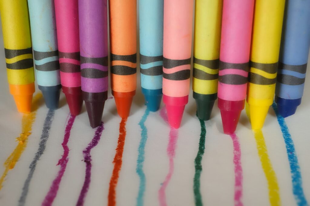 Krayon warna-warni berjajar dengan coretan warnanya
